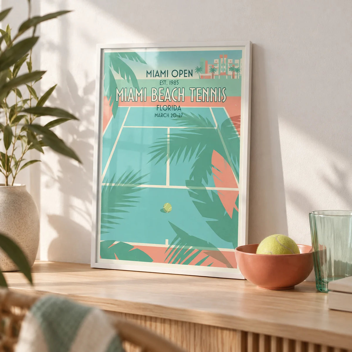 Miami Beach Tennis Print, a small A4 framed print leaning on a pale oak shelf in a living room