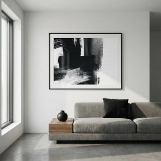 Modern living room with a gray sofa, wooden coffee table, and abstract black and white artwork on the wall.