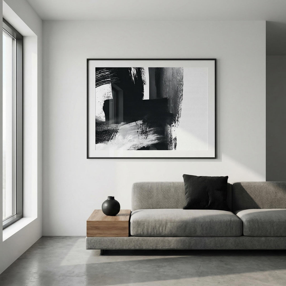 Modern living room with a gray sofa, wooden coffee table, and abstract black and white artwork on the wall.