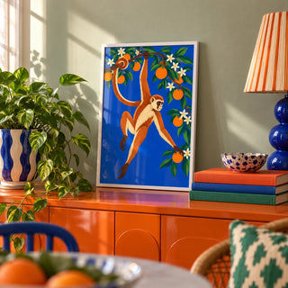 Monkey Wall Art, a small A4 framed print leaning on a colourful lacquered shelf in a living room