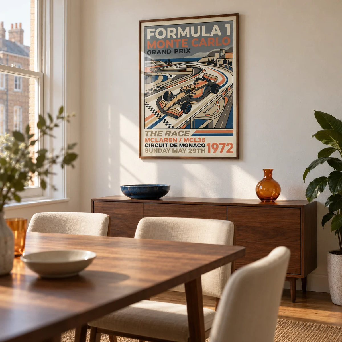 Monte Carlo Retro Racing Poster, framed on the wall of a compact dining room in a UK city flat with warm white plaster walls and a vintage walnut dining table