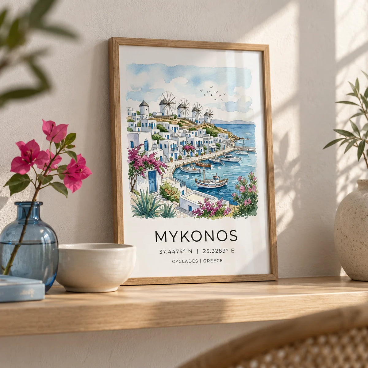 Mykonos Art Print, a small A4 framed print leaning on a pale oak shelf in a living room