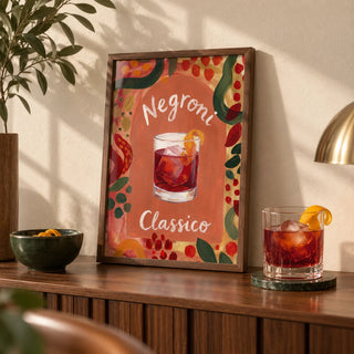 Negroni Art Print, a small A4 framed print leaning on a walnut home-bar sideboard in a living room