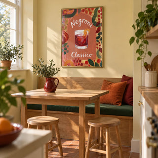 Negroni Art Print, framed on the wall of a sunny breakfast corner in a compact UK kitchen with pale butter-yellow walls and a built-in oak bench