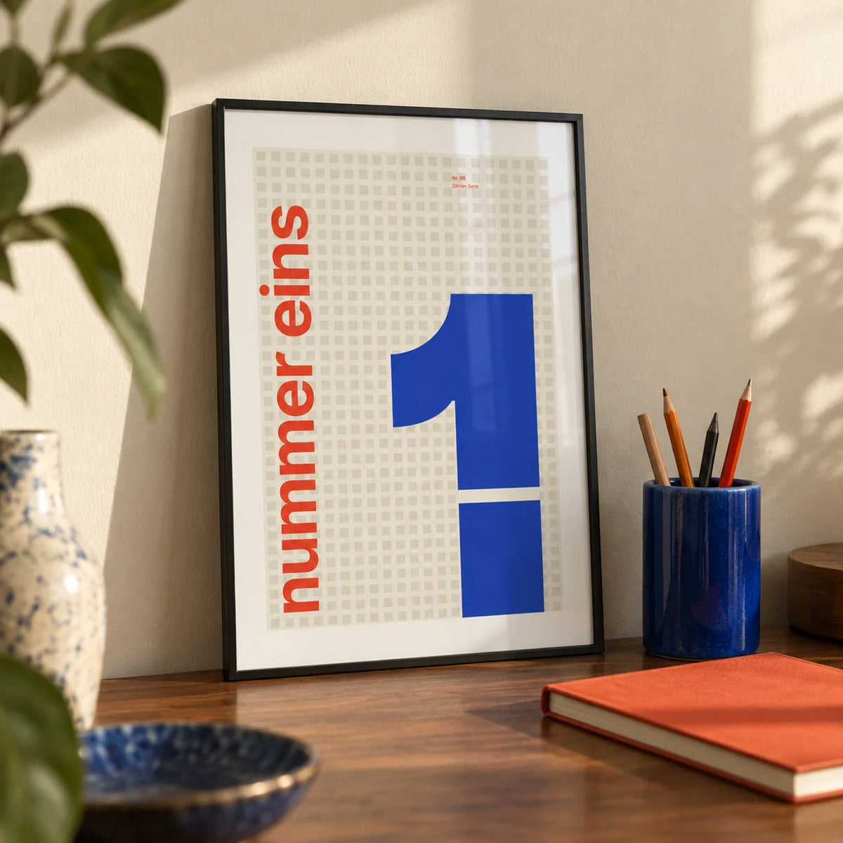 Number 1 Print, a small A4 framed print leaning on a walnut desk