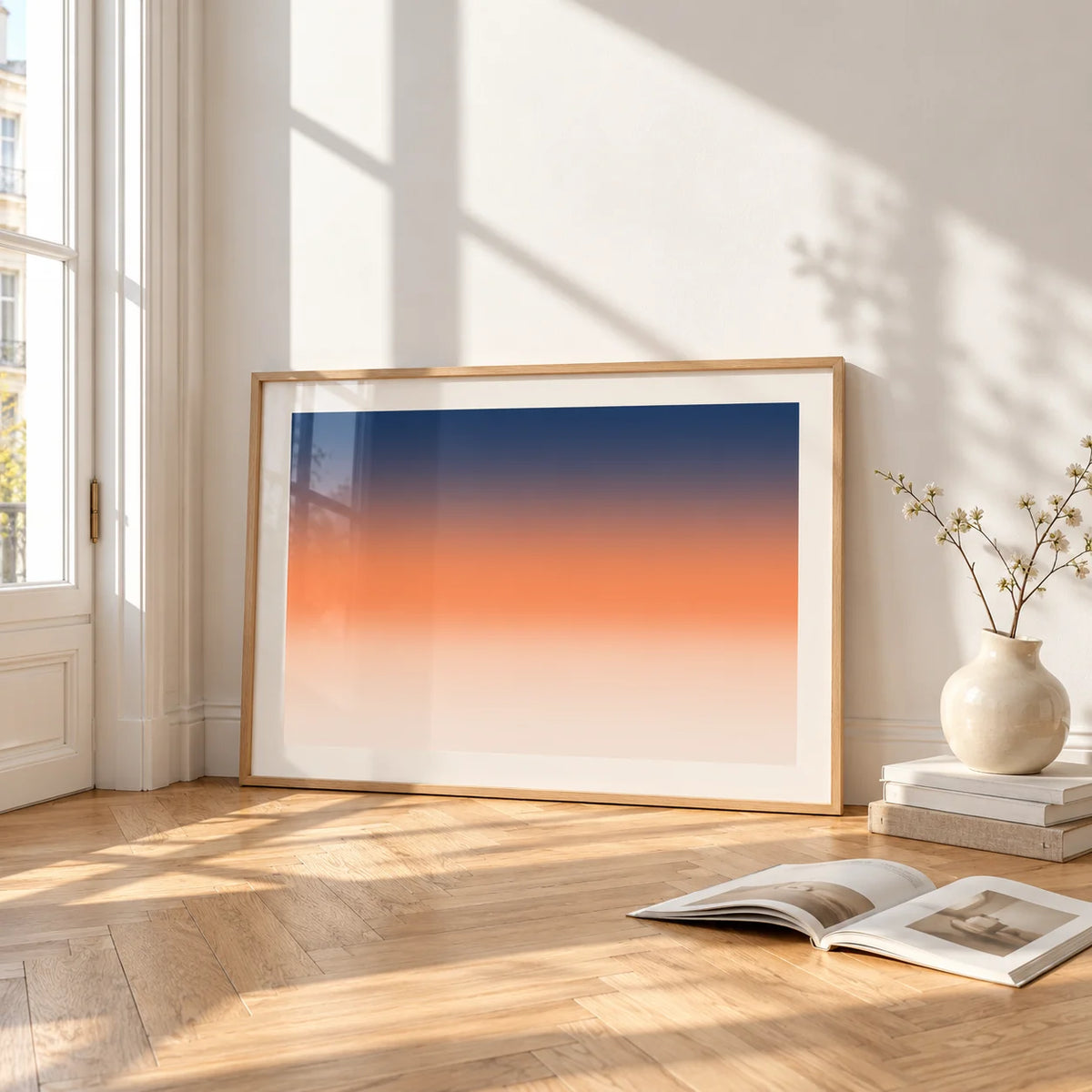 Ocean Sunset Poster, framed and leaning on the parquet floor of a bright living room