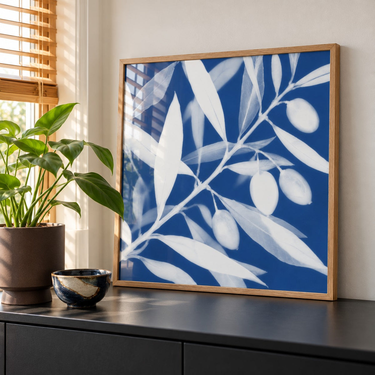 Olive Branch Cyanotype Print styled on a black sideboard (frame not included)
