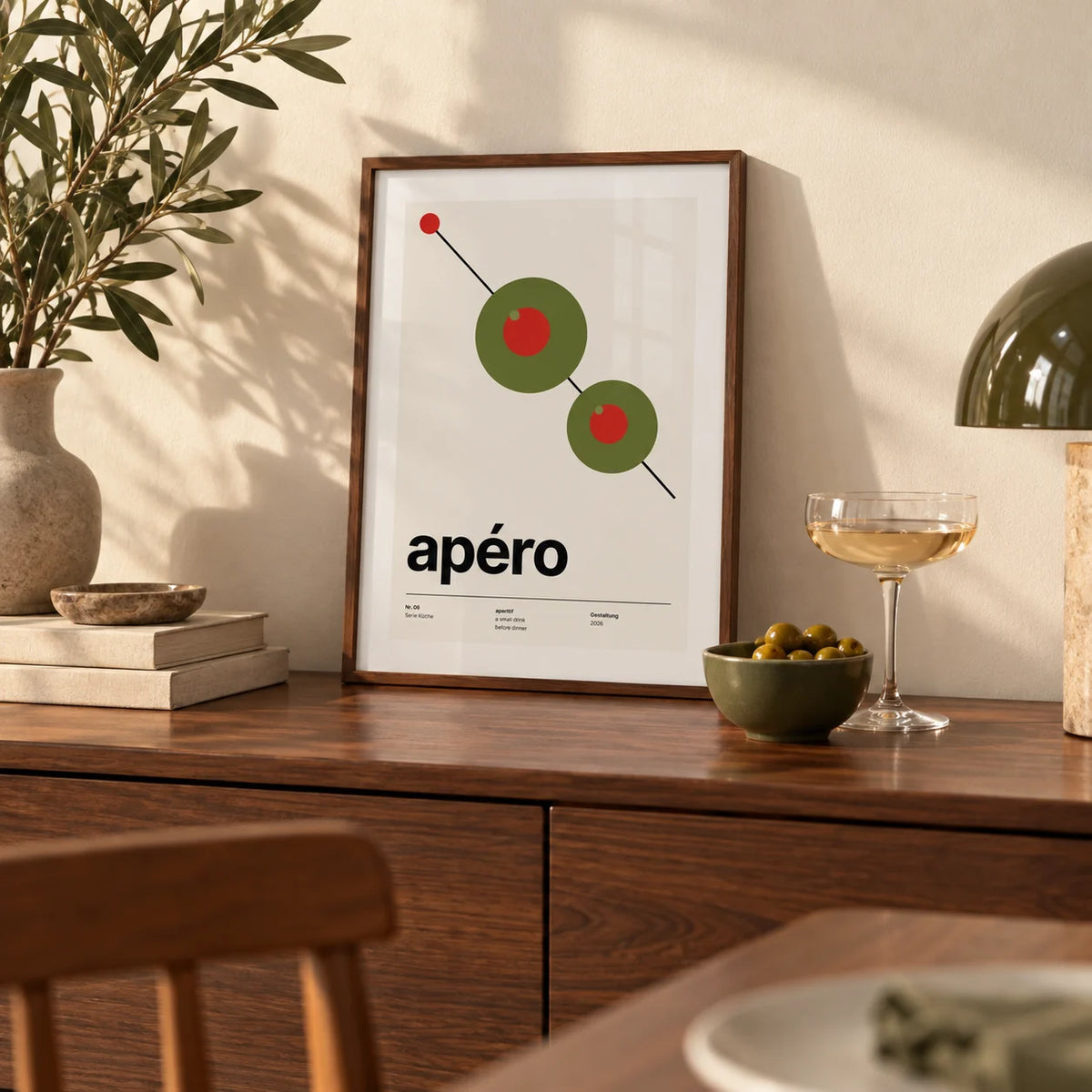 Olive Print, a small A4 framed print leaning on a walnut sideboard in a dining room