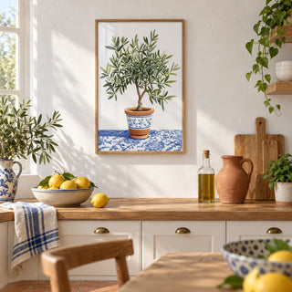 Olive Tree Art Print, framed on the wall of a bright Mediterranean kitchen with white plaster walls and a terracotta floor