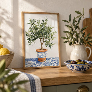 Olive Tree Art Print, a small A4 framed print leaning on an oak worktop in a kitchen