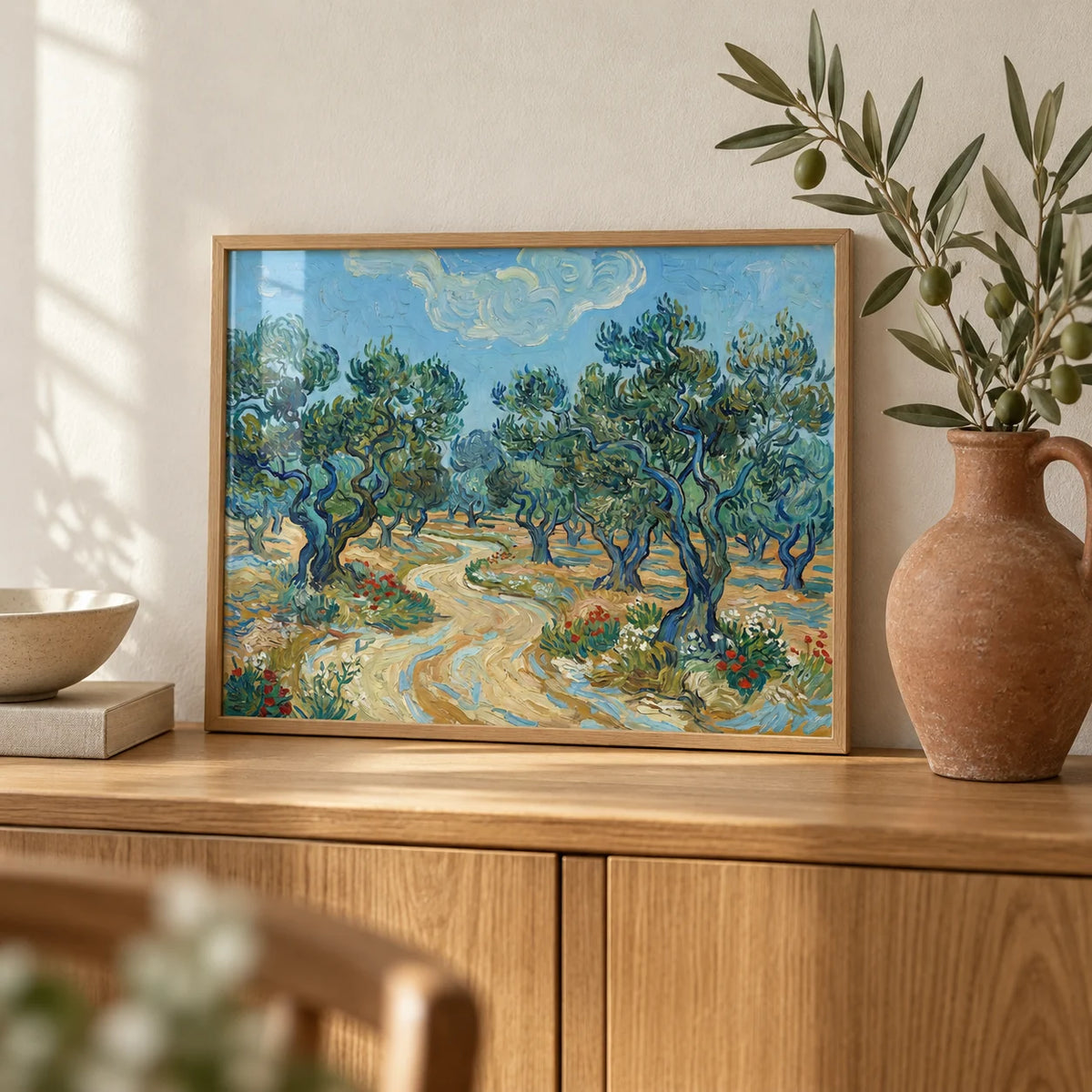 Olive Tree Landscape Print, a small A4 framed print leaning on an oak sideboard in a living room