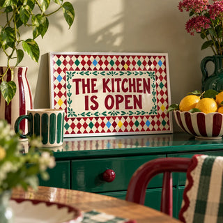 Open Kitchen Harlequin Print, a small A4 framed print leaning on a colourful lacquered shelf in a living room