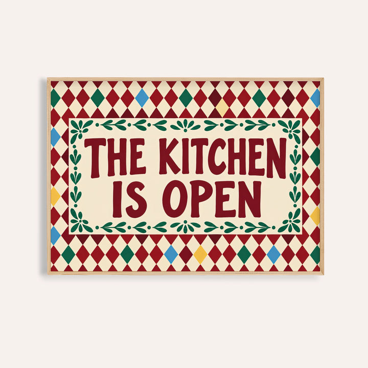 Open kitchen harlequin print reading THE KITCHEN IS OPEN on a burgundy harlequin pattern