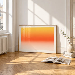 Orange Abstract Wall Art, framed and leaning on the parquet floor of a bright living room