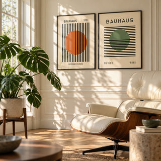 Orange and Green Wall Art Set of 2 styled on a sunlit wall beside a cream leather lounge chair and a monstera: Striped Sun and Modern Orb shown framed side by side (frames not included)
