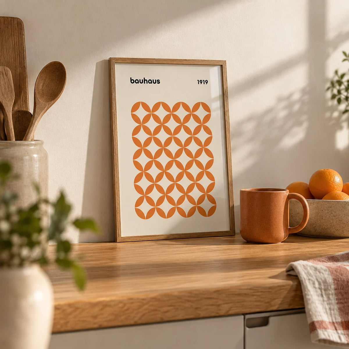 Orange Minimalist Print, a small A4 framed print leaning on an oak kitchen worktop