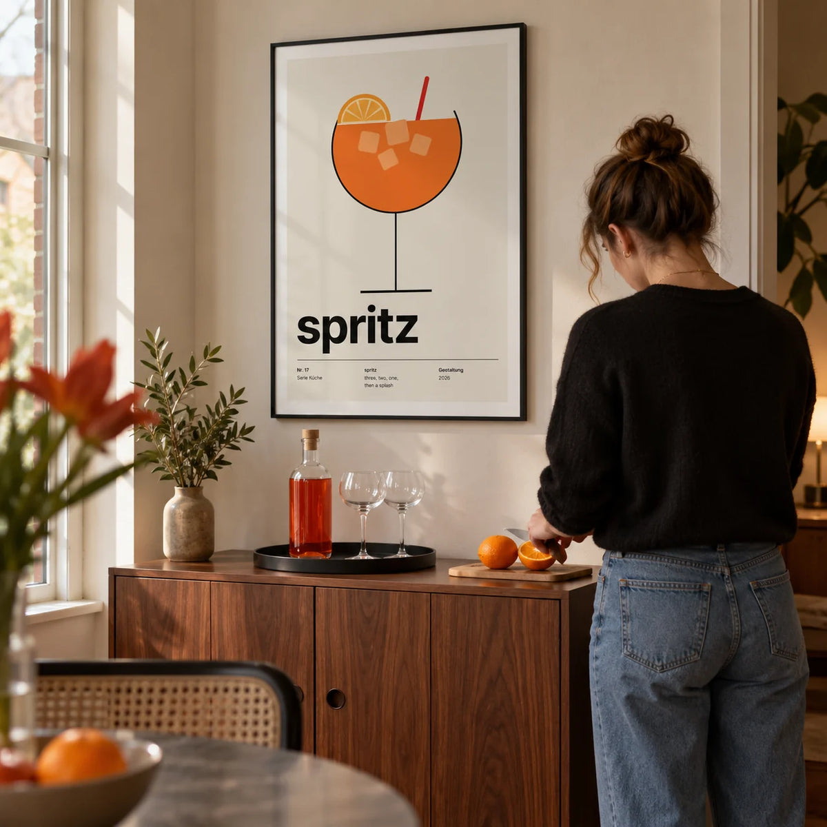 Orange Spritz Print, framed on the wall of a compact home bar corner in a modern UK flat with a cream wall and a walnut drinks cabinet in a living room