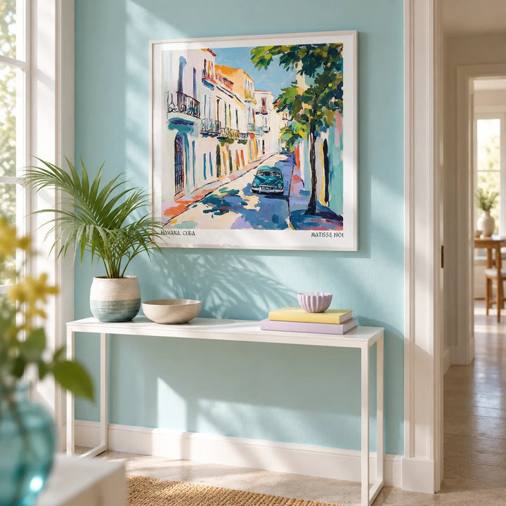 Paintings of Cuba, framed on the wall of a bright hallway with a pale turquoise painted wall