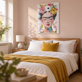 Paintings of Frida Kahlo, framed on the wall of a bright adult bedroom in a UK flat with pale blush walls and simple oak furniture
