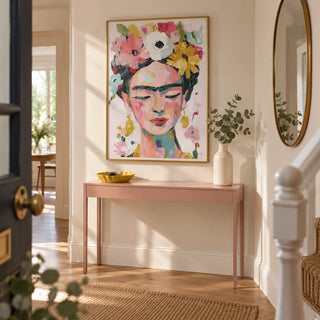 Paintings of Frida Kahlo, framed on the wall of a welcoming hallway in a renovated UK terrace with pale cream walls and a plain oak floor