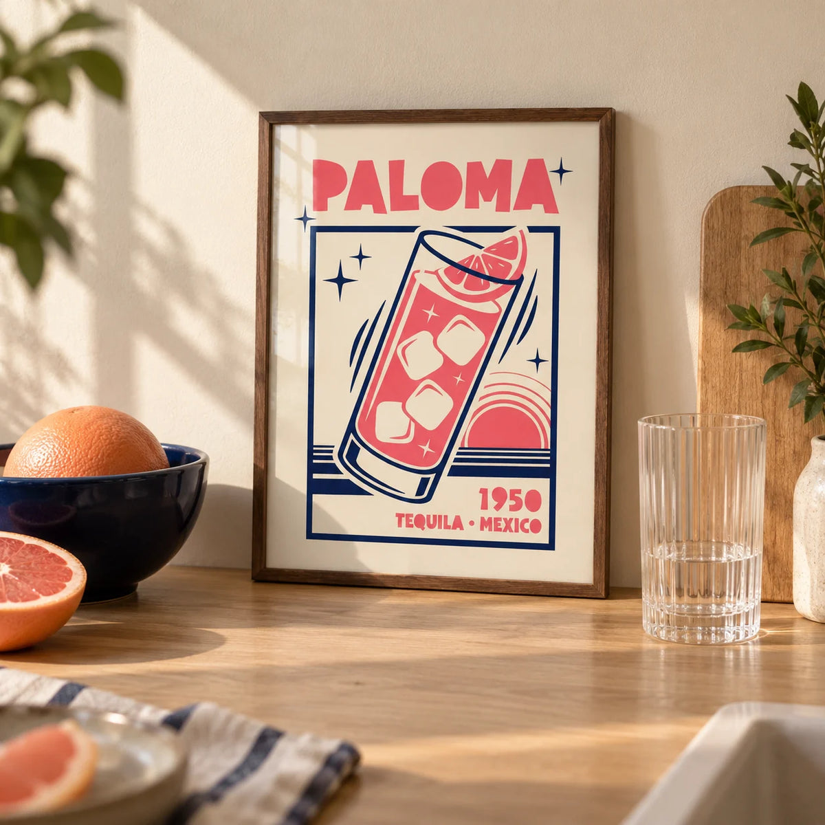 Paloma Cocktail Print, a small A4 framed print leaning on a pale oak kitchen worktop