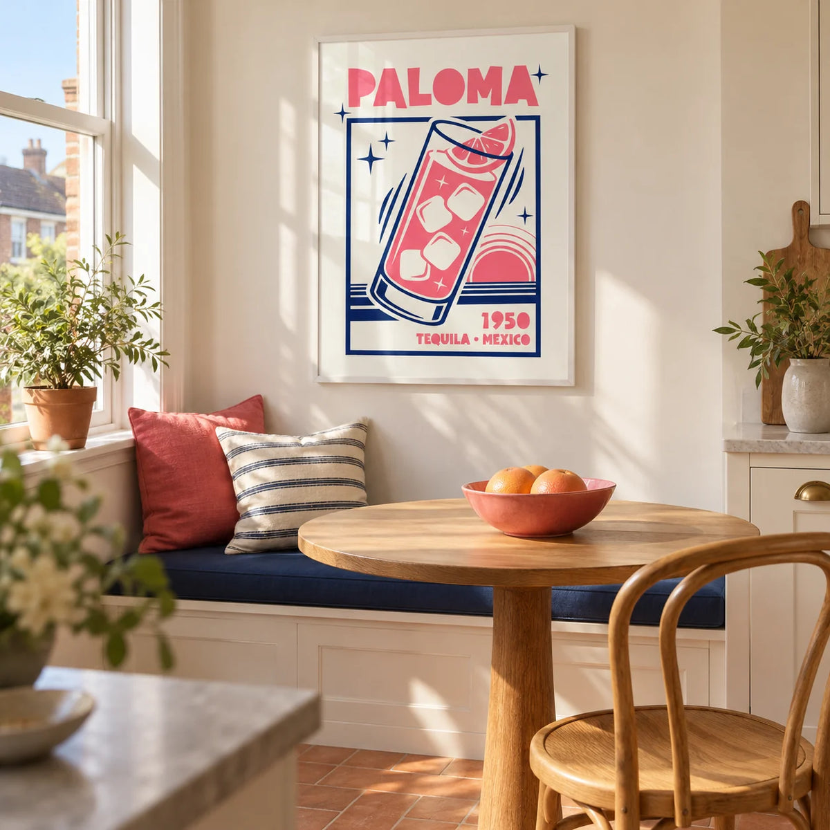 Paloma Cocktail Print, framed on the wall of a sunny kitchen breakfast nook in a UK maisonette with a cream wall and terracotta floor