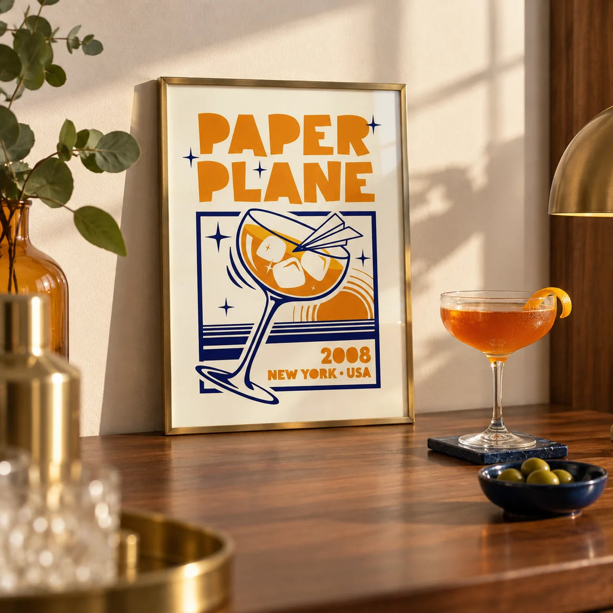 Paper Plane Cocktail Poster, a small A4 framed print leaning on a walnut home bar worktop in a kitchen