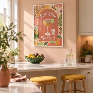 Passion Fruit Martini Poster, framed on the wall of a bright kitchen breakfast corner in a compact UK apartment with a pale peach wall and a white stone breakfast counter