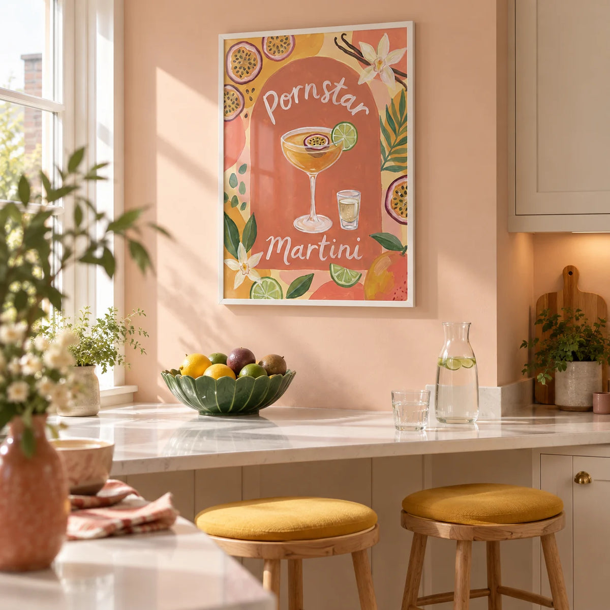 Passion Fruit Martini Poster, framed on the wall of a bright kitchen breakfast corner in a compact UK apartment with a pale peach wall and a white stone breakfast counter