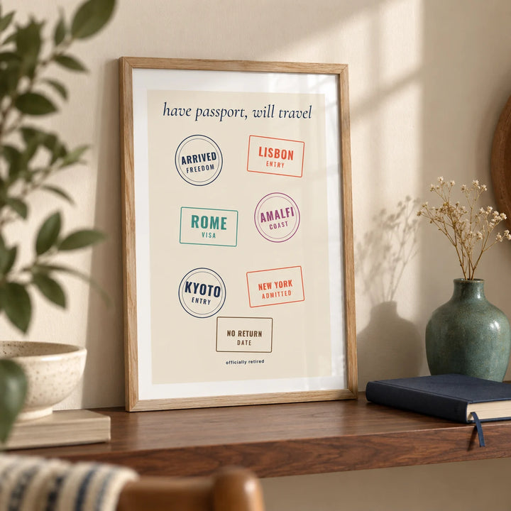 Passport Stamps Poster, a small A4 framed print leaning on a walnut shelf in a living room