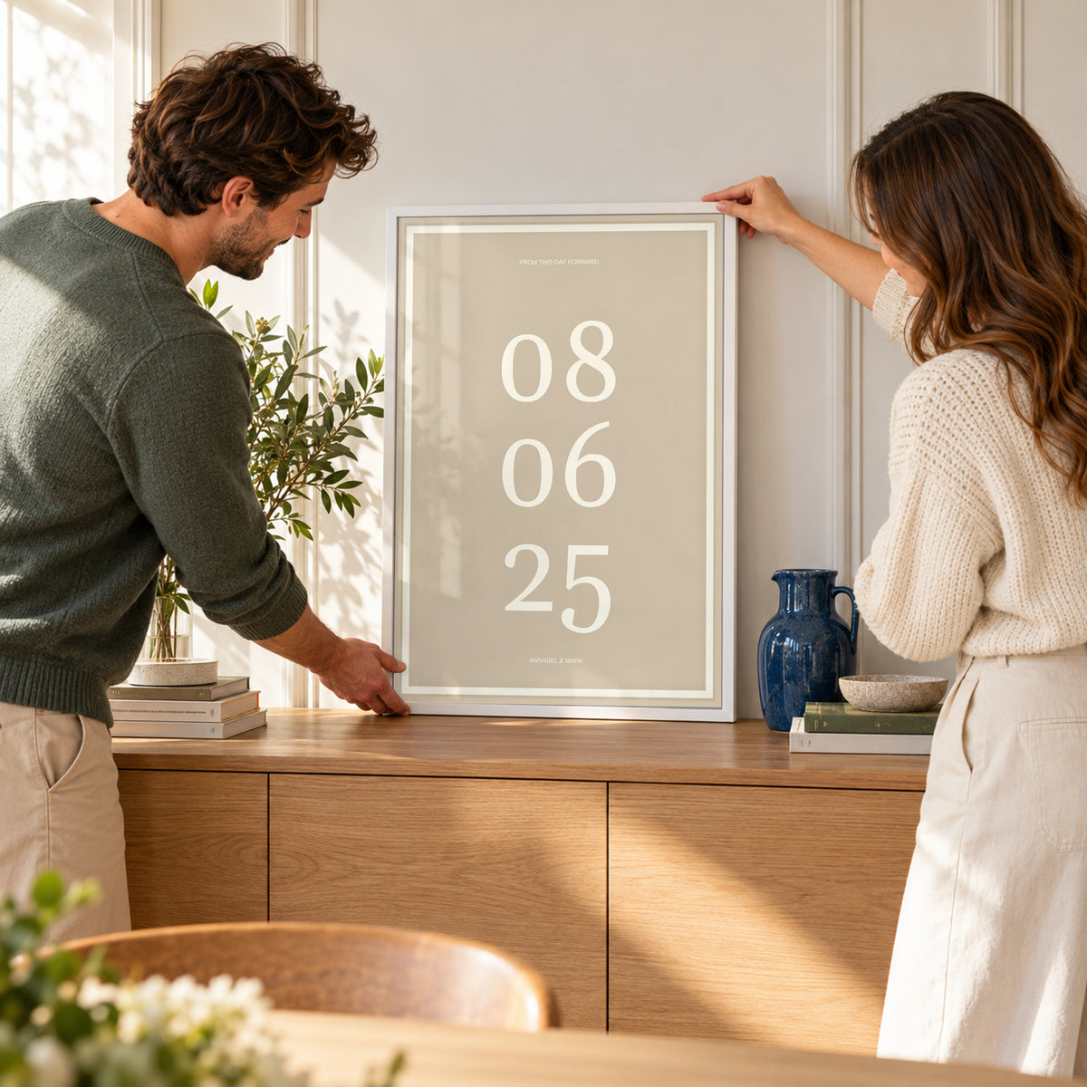 Anniversary Date Print in a couple arranging their home, white frame