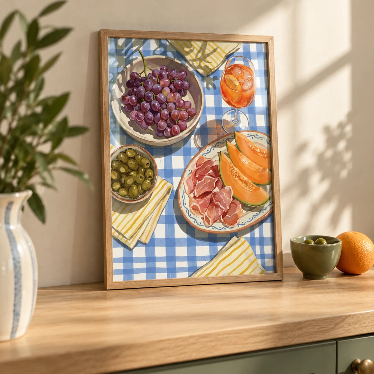 Picnic Decor Wall Art, a small A4 framed print leaning on a pale oak kitchen worktop