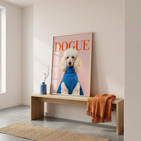 Framed picture of a dog wearing a blue sweater with 'DOGUE' text on a wall above a wooden bench.