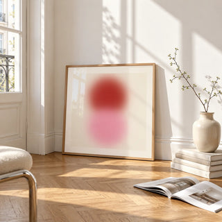 Pink and Red Print, framed and leaning on the parquet floor of a bright living room