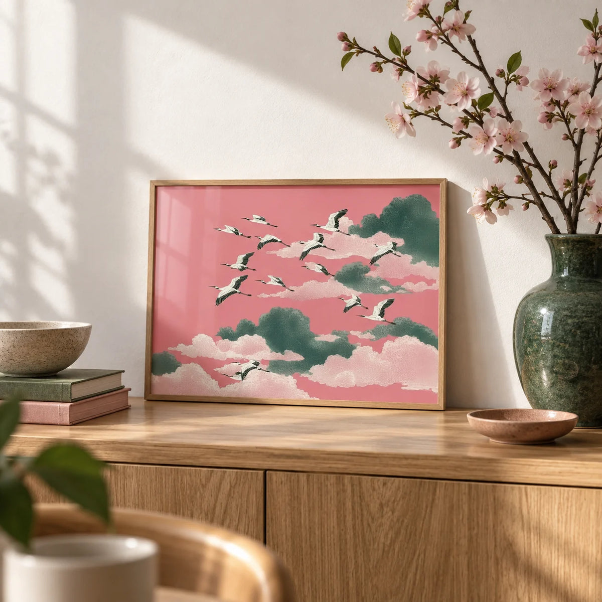 Pink Crane Wall Art, a small A4 framed print leaning on an oak sideboard in a living room