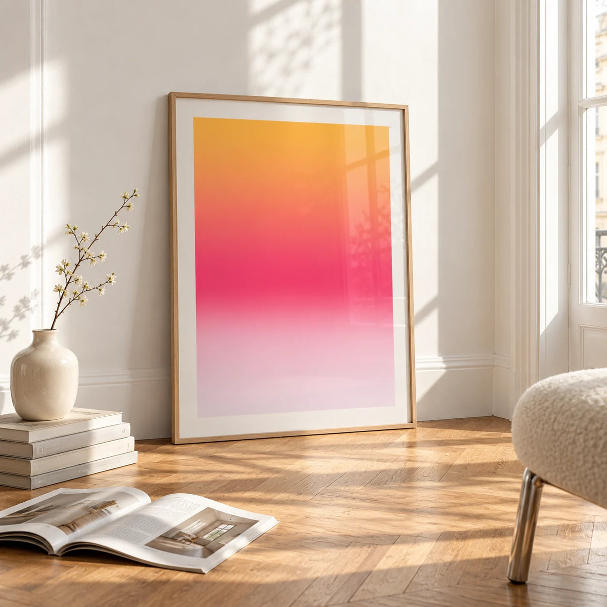 Pink Sunset Wall Art, framed and leaning on the parquet floor of a bright living room