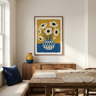 Dining room with wooden table, chairs, and a vase on a shelf. Wall art with flowers in a polka dot vase is displayed.