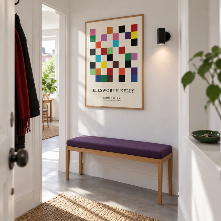 Posters for Office, framed on the wall of a bright entrance hallway in a renovated UK maisonette with white walls and a plain grey floor