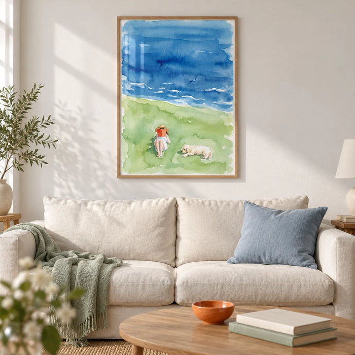 Reading By The Sea Art Print, framed on the wall of a calm coastal living room in a UK terraced home with chalk white walls and pale oak floorboards