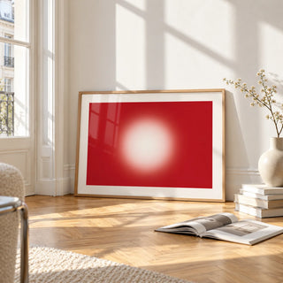 Red Abstract Wall Art, framed and leaning on the parquet floor of a bright living room