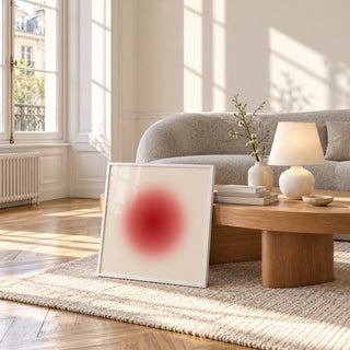 Red Circle Wall Art, framed and leaning against a coffee table in a bright living room