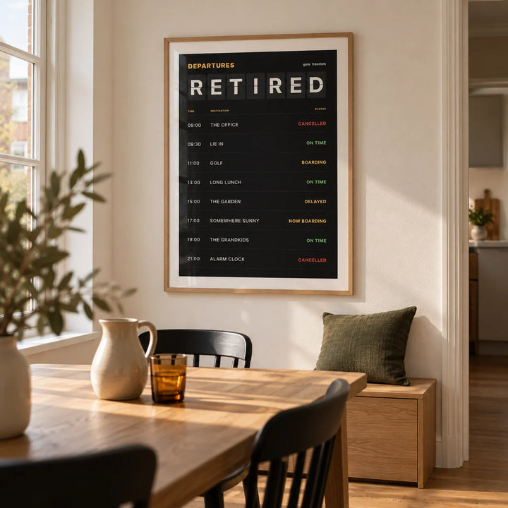 Retired Poster, framed on the wall of a modern dining nook in a UK townhouse with a warm white wall and plain oak flooring