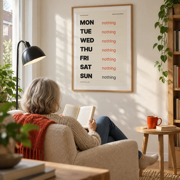 Retirement Plan Print, framed on the wall of a relaxed modern reading corner in a UK semi-detached home with an off-white wall in a living room