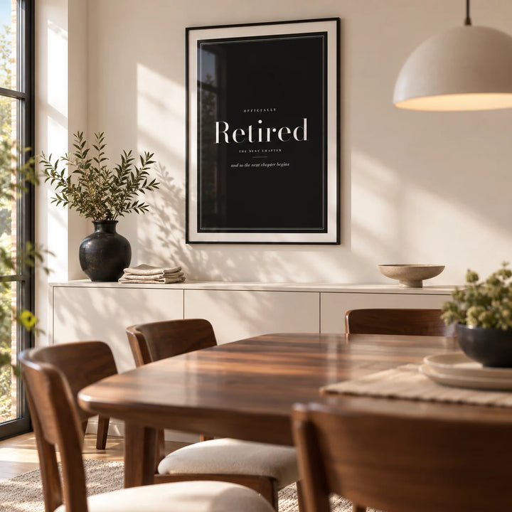 Retirement Poster, framed on the wall of a contemporary dining room in a UK family home with a warm white wall and a walnut dining table