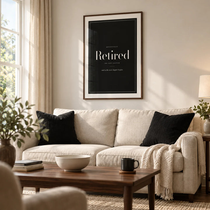 Retirement Poster, framed on the wall of a modern living room in a retired couple's UK home with a soft ivory wall