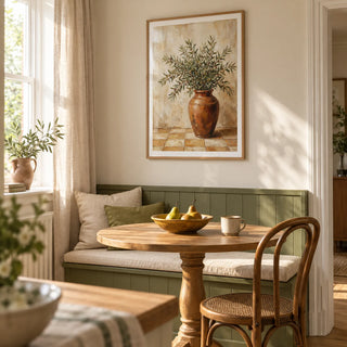 Rustic Olive Art, framed on the wall of a sunlit breakfast nook in a modest UK family home with pale cream walls and a built-in olive green bench in a kitchen