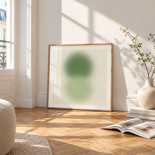 Sage and Olive Print, framed and leaning on the parquet floor of a bright living room