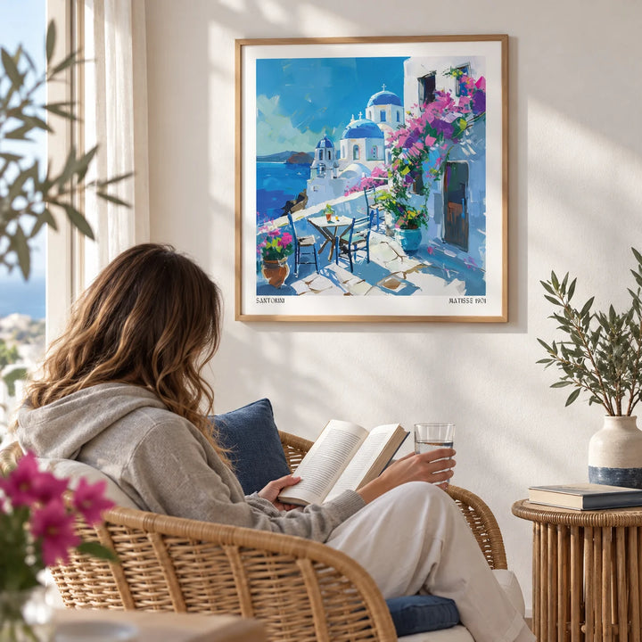 Santorini Wall Art Prints, framed on the wall of a breezy reading corner with a white wall in a living room