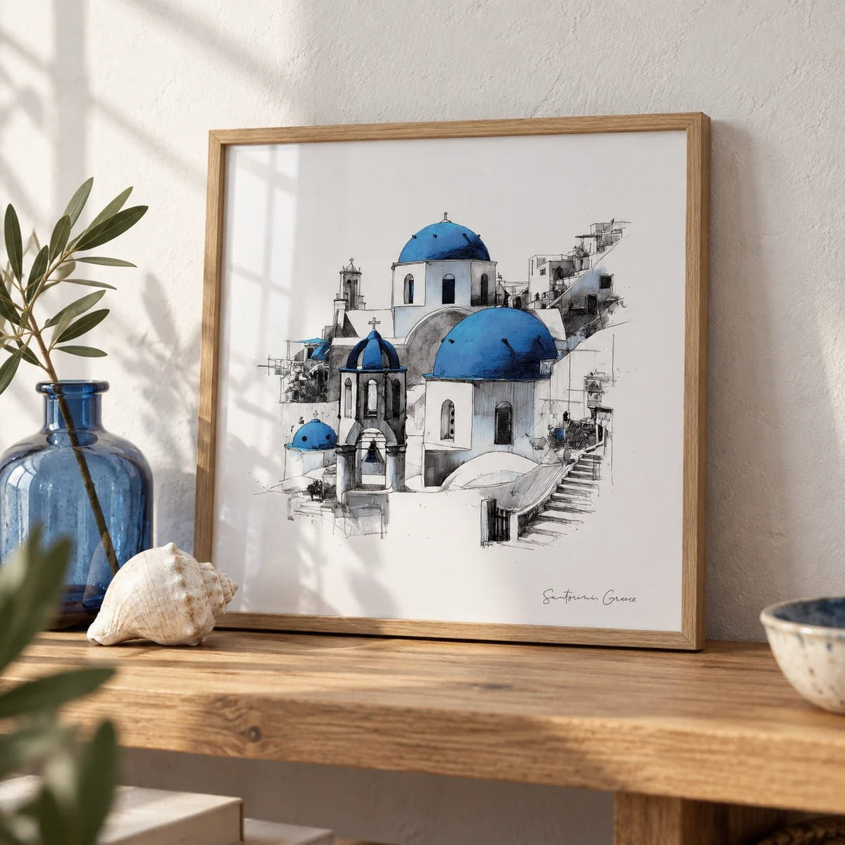 Santorini Wall Art, a small A4 framed print leaning on an oak shelf in a living room