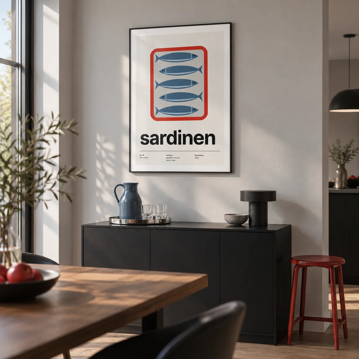 Sardine Print, framed on the wall of a modern home bar corner in an open-plan dining room with a pale grey wall and a low black drinks cabinet